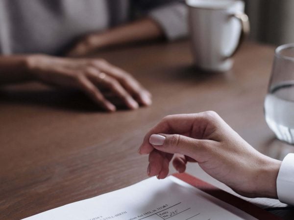 hands on a table with paperwork